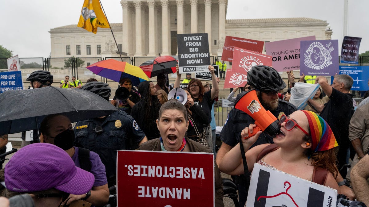 Abortion-rights protesters and anti-abortion protesters, divided by a police line, demonstrate in front of the Supreme Court in Washington, Thursday, June 23, 2022.