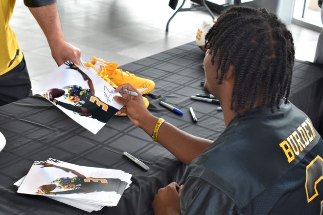 Missouri freshman wide receiver Luther Burden hands a fan an autographed photo during his NIL autographing event at the Mercedes-Benz of Columbia on June 24, 2022.