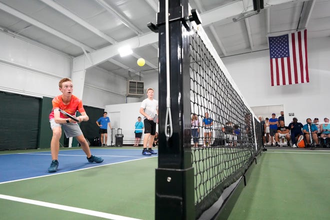 Connor Chaffin returns a shot while playing with partner Isaac Hinterschied during a pickleball exhibition during the Pickle Shack grand opening.