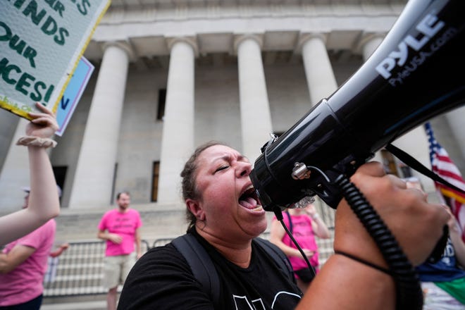 Amy Nachtrab, of Delaware, shouts into a bullhorn Sunday during a rally organized by the Democratic Party at the Ohio Statehouse following the overturning of Roe v. Wade.