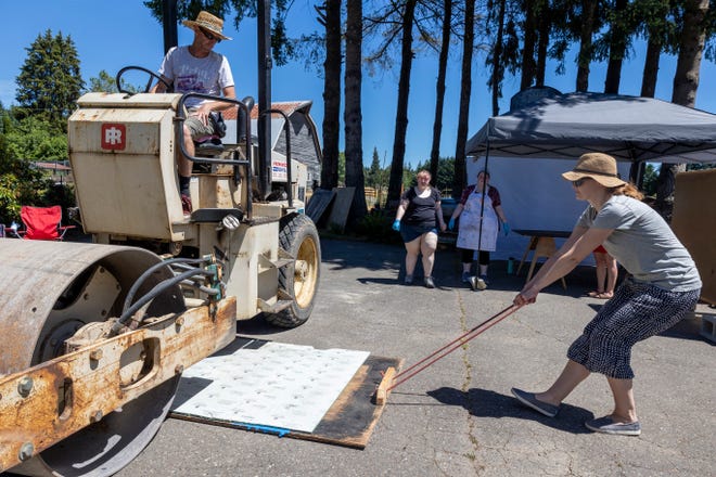 A print assembly is pulled from underneath a roller at Wayzgoose Kitsap 2022 on Saturday.