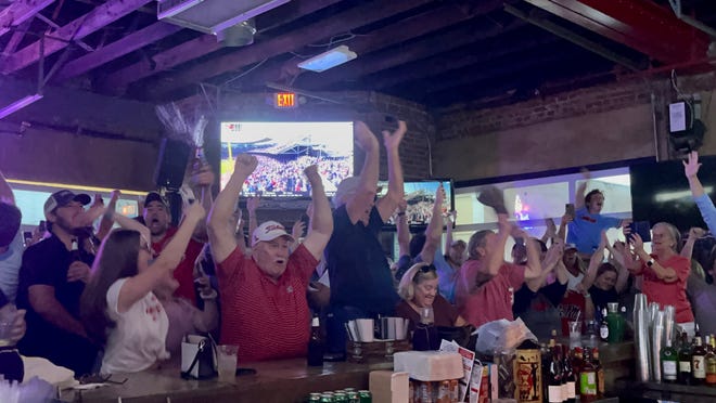 Fans at The Library sports bar in Oxford celebrate Ole Miss' 4-2 win over Oklahoma in the College World Series on Sunday.