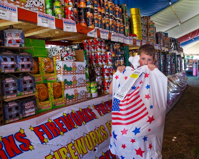 Eight-year-old Wesley Bodewitz helps out at the Factory Fireworks Outlet stand on Olympic Street in Springfield run by Crossfire Ministries. Proceeds from the annual sale go to Fundz4Kidz that supports a variety of activities for area children throughout the year.