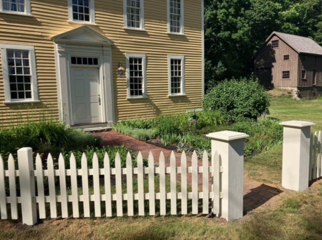 Spring 2022 photo of new fence installation in front Holyoke-French House and the enclosing Parlor Garden area.