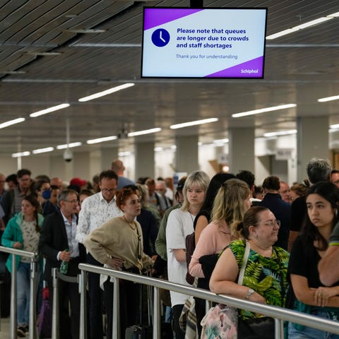 Travelers wait in long lines to check in and board