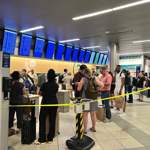 Delta Air Lines passengers wait in line for help a