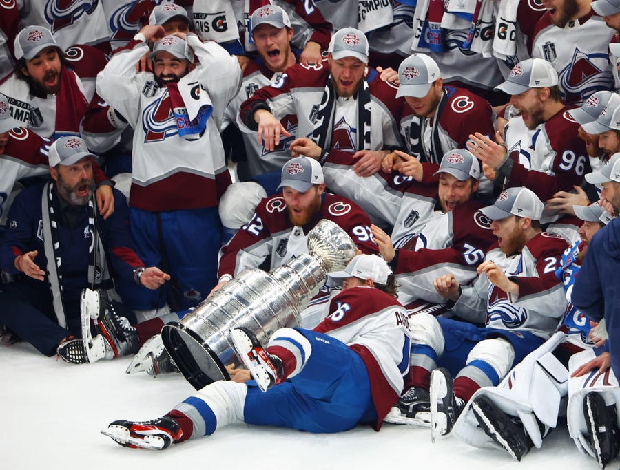 Colorado Avalanche players react as right wing Nicolas Aube-Kubel (16) falls and drops the Stanley Cup trophy on the ice after defeating the Tampa Bay Lightning to win the Stanley Cup in Game 6 of the Stanley Cup Final.
