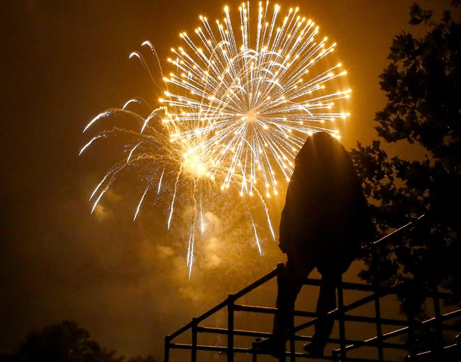 A kids sits onto of a jungle gym near the Hal Brady Recreation Center and watches the fireworks display dubbed "The Largest Small Town Fireworks Display in America," during Fourth of July Celebration in Alachua Fla., July 4, 2019.