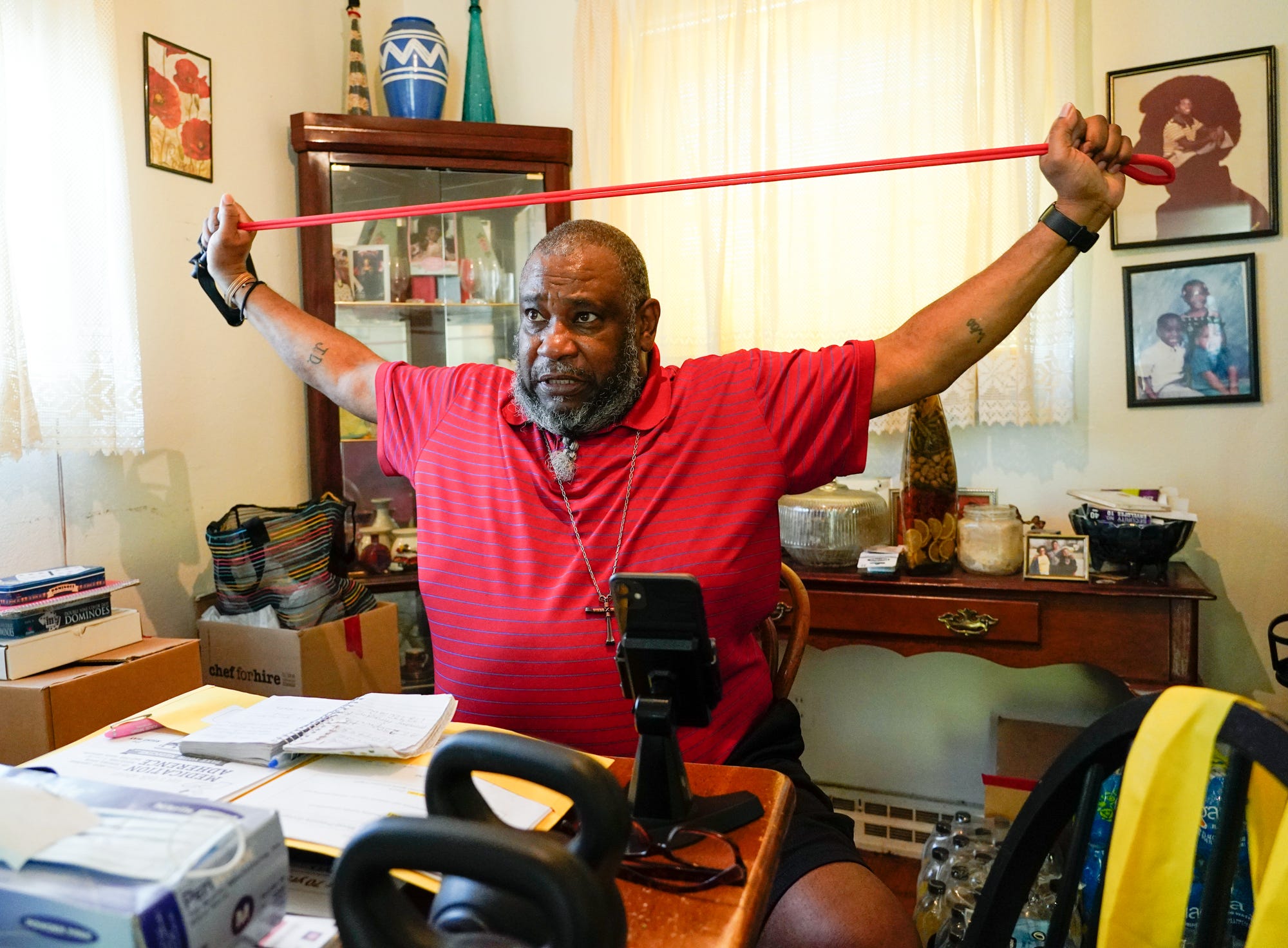 At his Indianapolis home, Nathaniel Brown demonstrates stretch band exercises he learned through a virtual health class.
