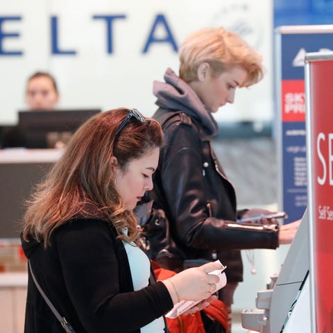 FILE - Travelers use the Delta airlines self check