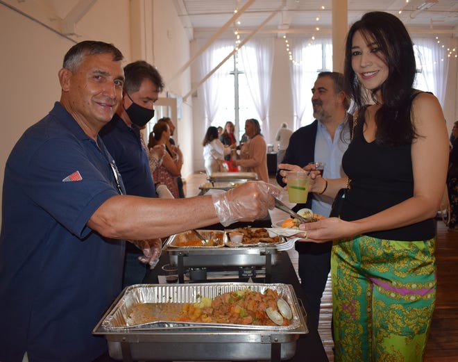 Azorean Maritime Heritage Society President Donald Rei serves Carne à Alentejana to guest Elisa de Melo at the organization's Sails of Portugal fundraiser.