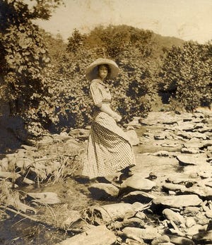 A woman poses at the Swannanoa River in the early 1900s.