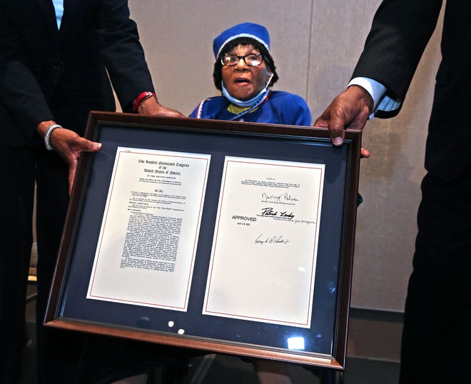 Edna Cummings, left, and Carlton Philpot hold the legislation for Anna Mae Robertson, who was awarded the Congressional Gold Medal for her service in WWII on Monday, June 27, 2022, at the Milwaukee County War Memorial Center.