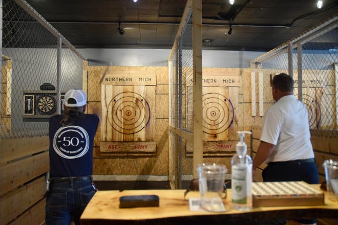 Pat Mousseau (right) from Birchwood Contruction and Gregg Garver (left) from the Harbor Springs Chamber of Commerce throw axes in a contest at Northern Michigan Axe Company on Wednesday to determine which group will set up their fireworks first on the Fourth of July.