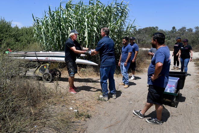 Jack Powers, left, 61, accepts water, food and hygiene supplies from Brent Ferguson and a team from Ventura County Rescue Mission on June 29. The rescue mission is branching out into other areas of Ventura County.