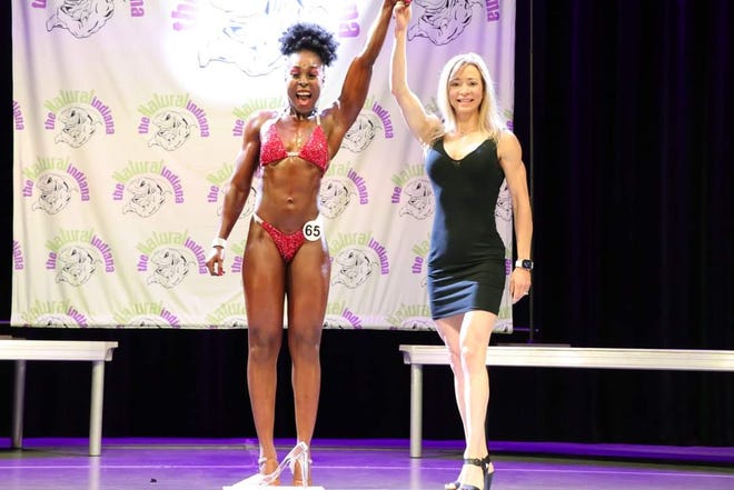 Taneisha Henline, left, celebrates after she was announced the overall winner in Figure at the 2022 NPC Natural Indiana Championships at Beech Grove High School.
