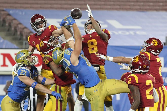 UCLA and USC players scramble to bring down a pass during the teams' football game in 2020. The Bruins' and Trojans' athletic programs are scheduled to join the Big Ten in 2024.