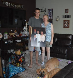 Kris Bieniewicz and her son Kyle stand with a family portrait inside their home on Wednesday, June 22, 2022.