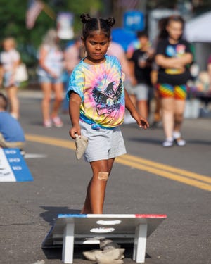 Seven-year-old Justice Stevens plays one of the family-friendly games provided by Leeda Northeast on Main Street in downtown Ravenna during the Ravenna Rocks concert series.