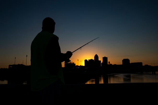 A person fishes on the Scott Avenue bridge Saturday, July 2, 2022 in Des Moines.