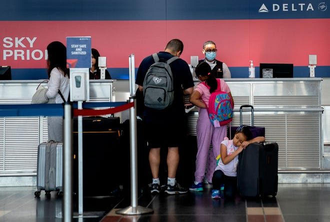 A Delta Airlines employee assists travelers at Ronald Reagan Washington National Airport on Saturday, July 2, 2022, in Arlington, Virginia. (Stefani Reynolds/AFP/Getty Images/TNS)