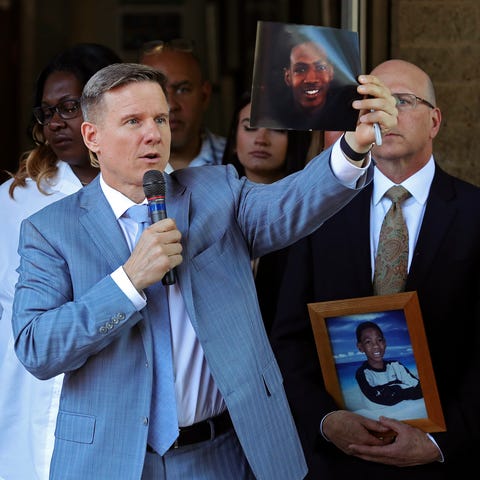 Attorney Bobby DiCello, right, holds up a photogra