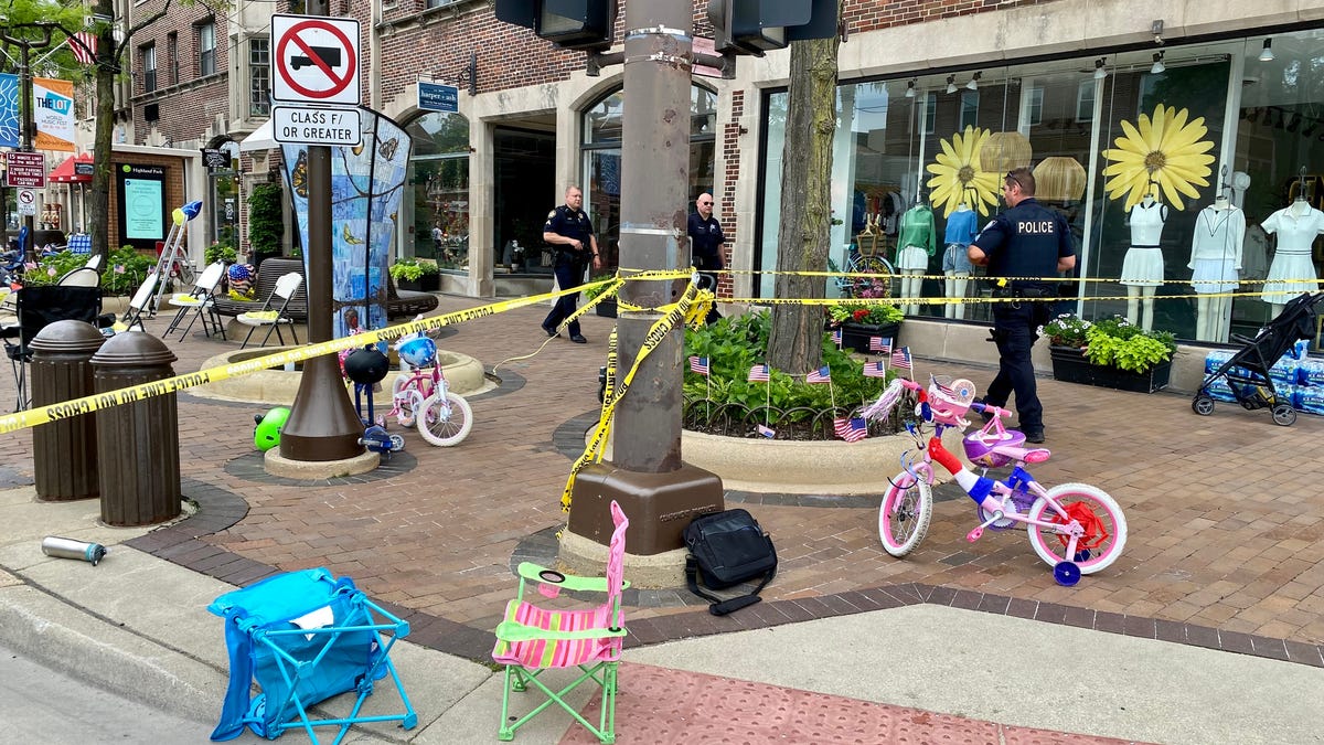 Law enforcement officers walk around a crime scene after a shooting at a parade on July 4, 2022, in Highland Park, Ill.