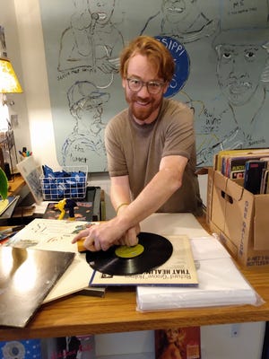 Assistant Manager Sam Lane gets ready for Thursday’s Fondren Live concert at The End of All Music, a record store on North State Street.
