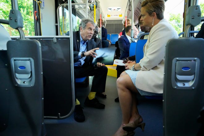 Jul 7, 2022; Columbus, Ohio, United States;  Sen. Sherrod Brown talks with COTA president and CEO Joanna Pinkerton as they ride a COTA bus down Broad Street through Franklinton, the route that will eventually be part of the LinkUS bus rapid transit system. Mandatory Credit: Adam Cairns-The Columbus Dispatch