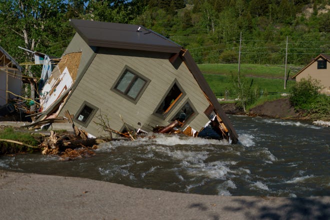 A house sits in Rock Creek after floodwaters washed away a road and a bridge in Red Lodge, Mont., on June 15. As cleanup from historic floods at Yellowstone National Park grinds on, climate experts and meteorologists say the gap between the destruction in the area and what was forecast underscores a troublesome trend tied to climate change: Modeling programs used to predict storms aren't keeping up with increasingly extreme weather.
