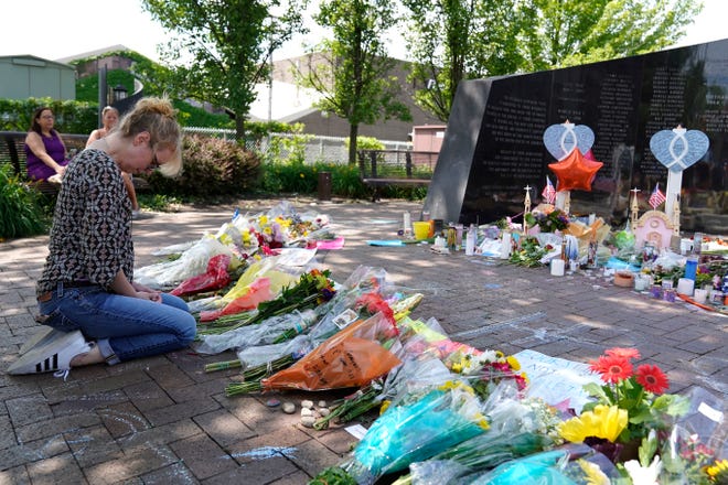 A visitor prays at a memorial to the seven people killed and others injured in Monday's Fourth of July mass shooting at the Highland Park War Memorial in Highland Park, Ill., Thursday, July 7, 2022. 