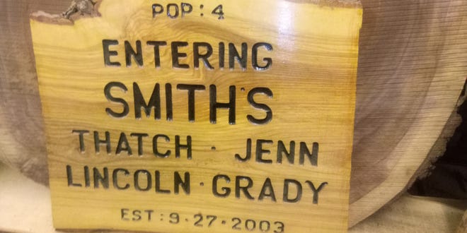Plymouth Live Edge owner Satch Smith's uncle, who owns a mill in Maine, presents a custom sign to his nephew in the names of Thatch, his wife, Jen, and their children, Lincoln and Grady. did
