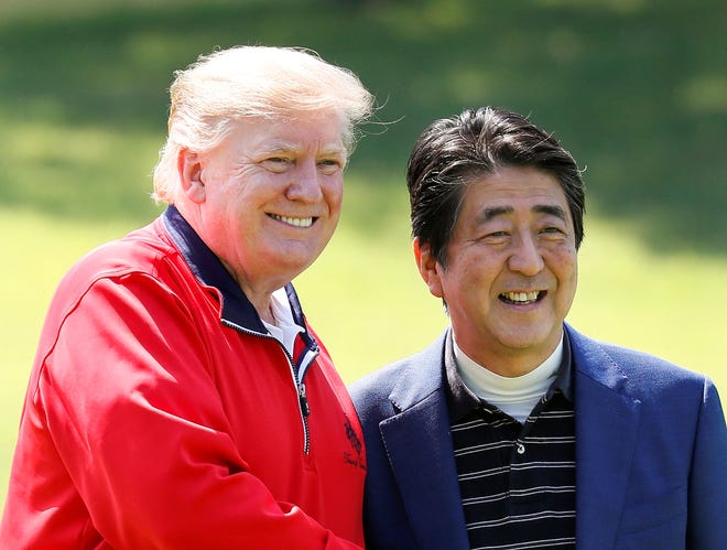De Japanse premier Shinzo Abe en de Amerikaanse president Donald Trump glimlachen voordat ze een rondje golf spelen bij de Mobara Country Club in Chiba.