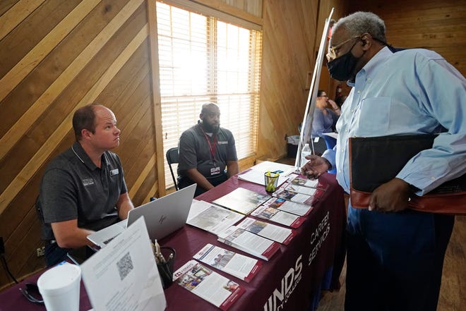 Robert Allen, director of work based learning, left, and Rod Mallett, work based learning coordinator, center, at Hinds Community College, discuss programs and opportunities with a job seeker, right, during the 2022 Mississippi Re-Entry Job Fair, in Jackson, Wednesday, June 22, 2022.