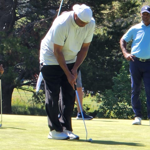 Charles Barkley putts on No. 14 Sunday while Marcu