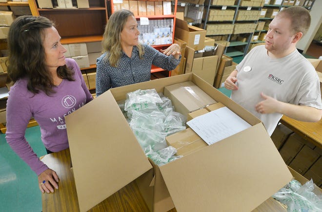 Melani Scott, left, general manager of ReCap Mason Jars, joins founder and owner Karen Rzepecki, 60, and Keystone Research Corporation employee Jack Dill, 26, right, inside the company's fulfillment center in Millcreek Township on July 11, 2022. KSRC is a third-party logistics partner with ReCap. In her tenth year of business, Rzepecki announced that the product line will be carried in Walmart stores early next year.