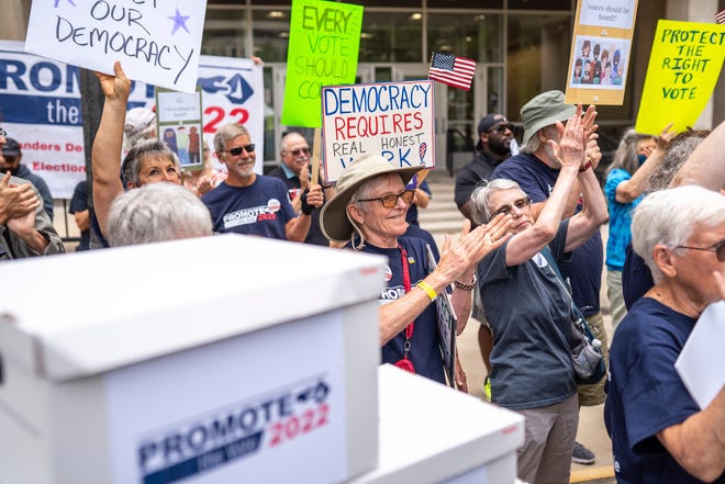 Volunteers gather for a news conference for Promote the Vote outside of the Richard Austin Building in Lansing on Monday, July 11, 2022.