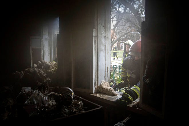 Petugas penyelamat melihat ke jendela sebuah rumah yang hancur setelah serangan Rusia di lingkungan perumahan di pusat kota Kharkiv, Ukraina, pada Senin, 11 Juli 2022.