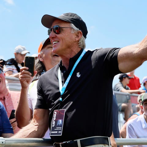 Greg Norman talks to fans during the second round 