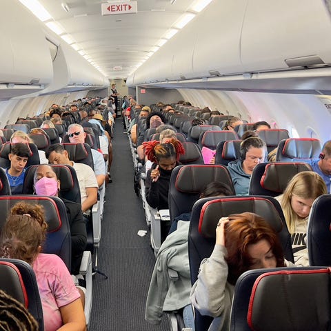 Passengers sit on board an airplane as they travel