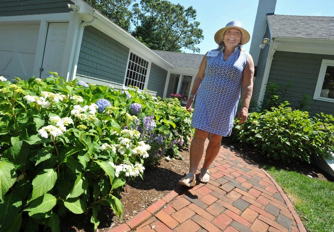 Andrea Brandeis walks past her hydrangea garden at her Duxbury home during the hydrangea garden tour hosted by the Community Garden Club of Duxbury, Tuesday, July 12, 2022.