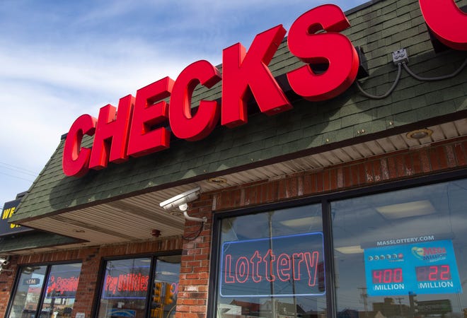 All Checks Cashed in Everett, Mass., is seen, April 21, 2022. All Checks Cashed is one of nearly 150 businesses licensed by the state of Massachusetts to cash checks and sell lottery tickets. Check cashers sold nearly $36 million in lottery products from 2017 through 2020.