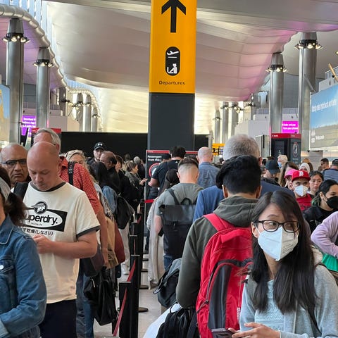 FILE - Travellers queue at security at Heathrow Ai