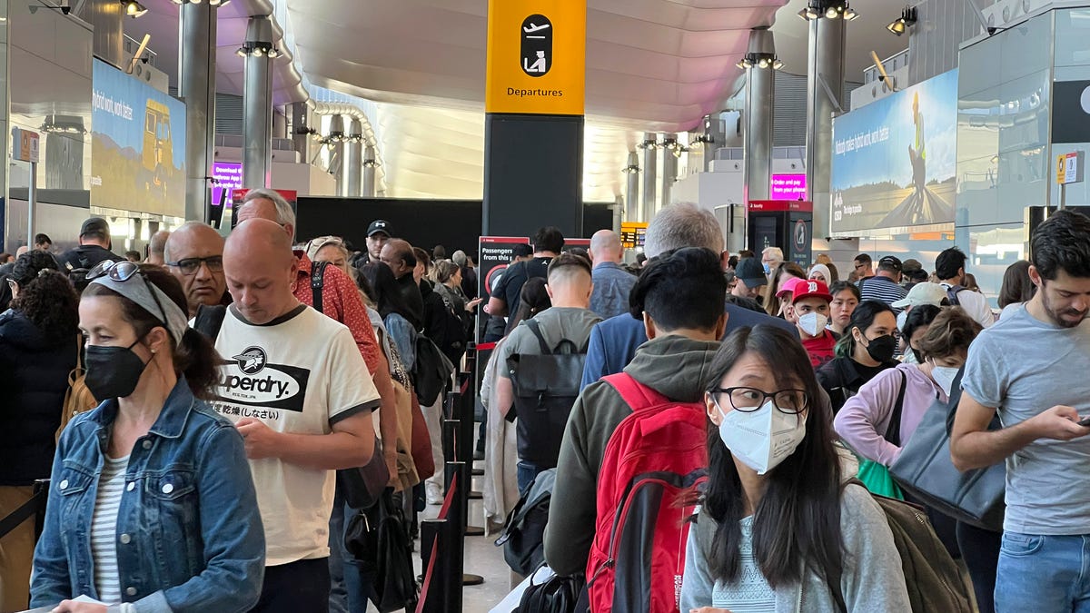 FILE - Travellers queue at security at Heathrow Airport in London, Wednesday, June 22, 2022. London's Heathrow Airport  apologized Monday, July 11, 2022 to passengers whose travels have been disrupted by staff shortages. The airport warned that it may ask airlines to cut more flights from their summer schedules to reduce the strain if the chaos persists. (AP Photo/Frank Augstein, File) ORG XMIT: LBL101