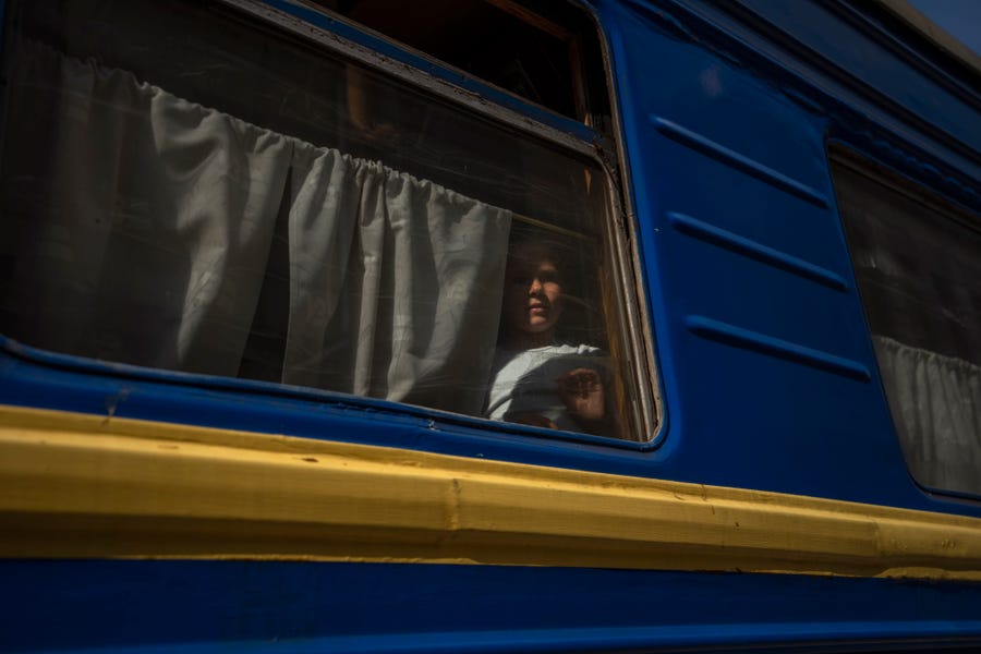 An internally displaced girl looks out the window of a train heading to Dnipro, in the Pokrovsk train station, Donetsk region, eastern Ukraine, Wednesday, July 6, 2022.