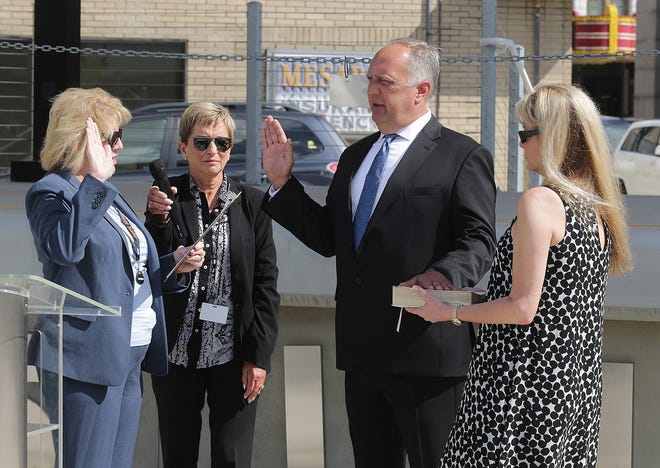 Massillon Mayor Kathy Catazaro-Perry (left) swears in interim Police Chef Bill Peel on Wednesday morning at the downtown Duncan Plaza. Peel's girlfriend, Renee Gordon, stands next to him holding the Bible. Safety-Service Director Barb Sylvester is pictured next to the mayor.