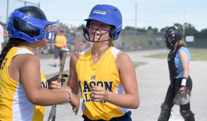 Kensey Kreger is greeted by Mason teammate Ava Belair after scoring a run on Day 2 of the 48th annual Monroe County Fair Softball Tournament. The catcher for Frenchtown Madison Duvall.