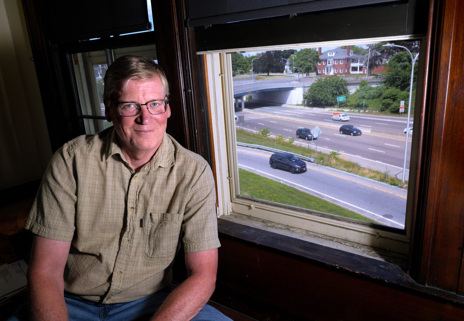 Steve Olausen, executive director of the Public Archaeology Laboratory, has a view of the Pawtucket S curve from a second-floor window at his office in the former To Kalon Club.