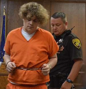 A 52-2 District Court judge in Clarkston ruled that Steven Morrow, 18, of Highland Township should stand trial on charges alleging he killed a pair of friends in White Lake Township. Here, he prepares to sit down at a table.