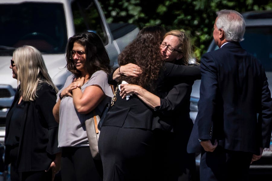 Mourners hug as they walk into Weinstein & Piser Funeral Home in Wilmette, Illinois, for the funeral for Irina McCarthy, who was killed in a mass shooting that left more than three dozen others injured during Highland Park's Fourth of July parade, Tuesday morning, July 12, 2022.
